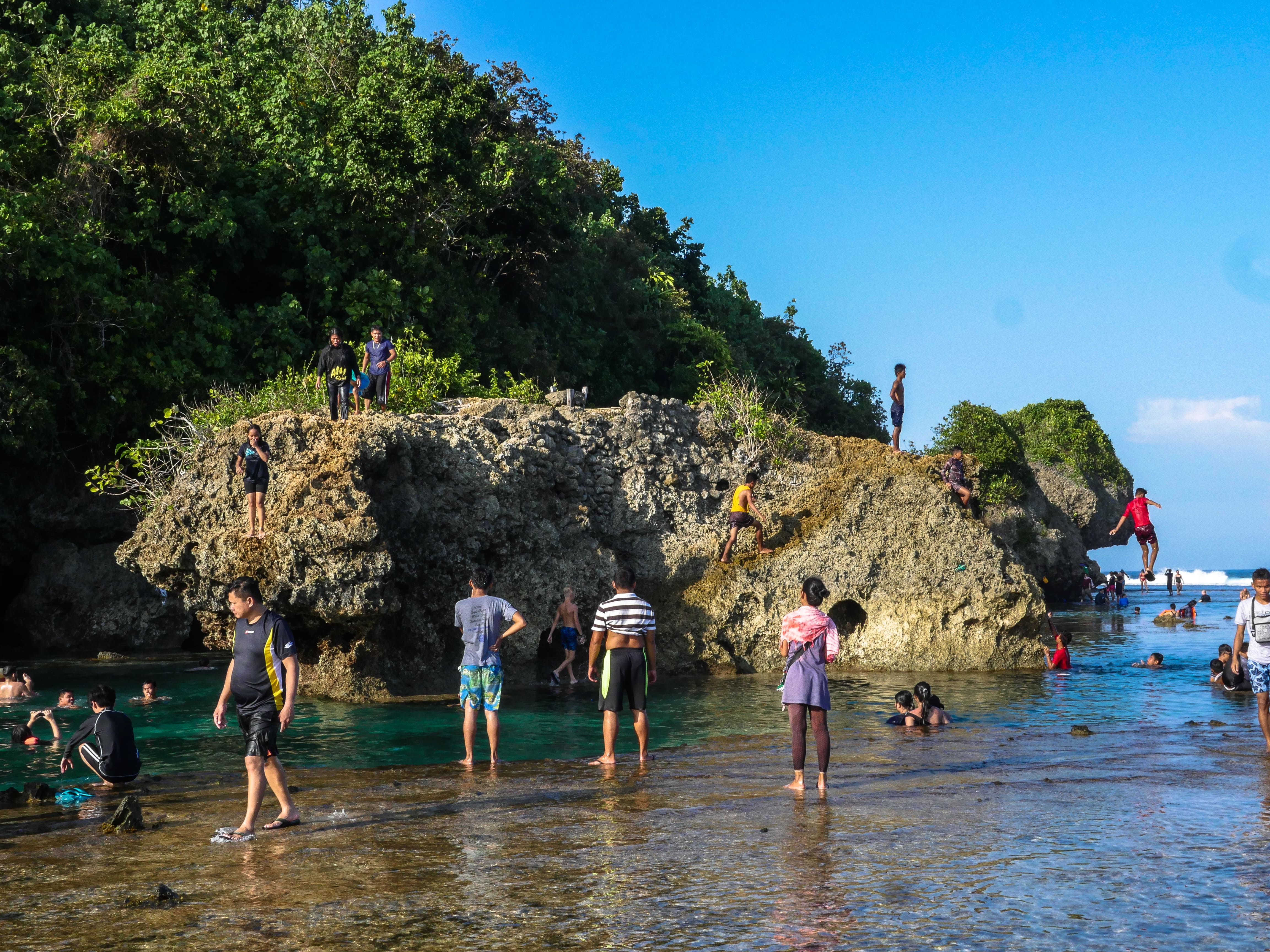 people amusing themselves at magpupungko rock pools and cliff jumping in siargao island